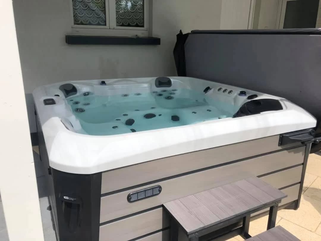 Installation d'un spa Kenya, sur une terrasse carrelée contre la maison