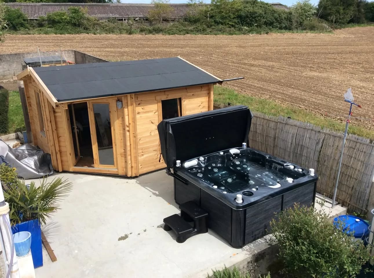 Installation d'un autre spa Bjørgan Full option, sur une dalle près d'un abri de jardin en bois