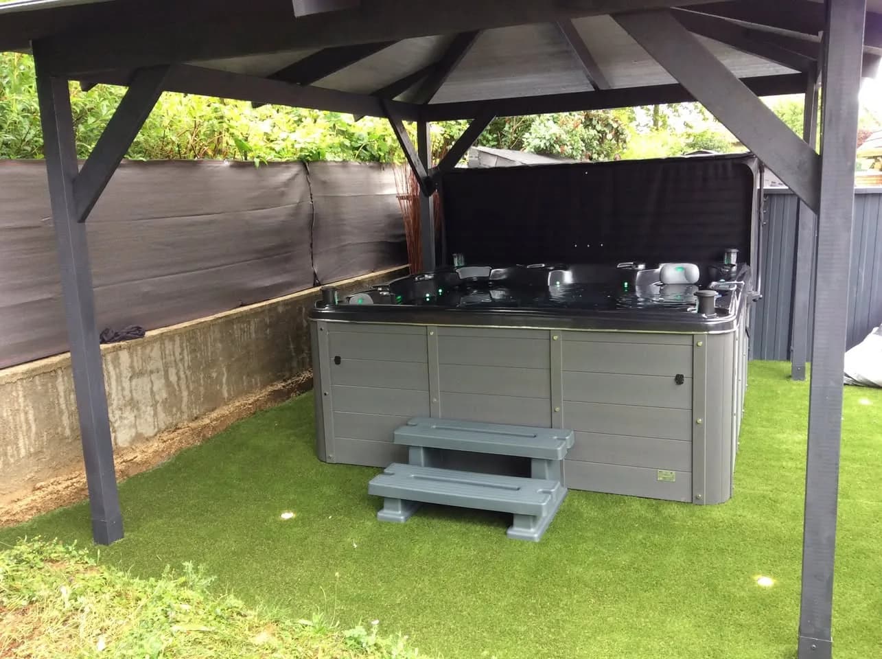 Installation d'un autre spa Cambridge Duel, sous un abri, sur du gazon synthétique