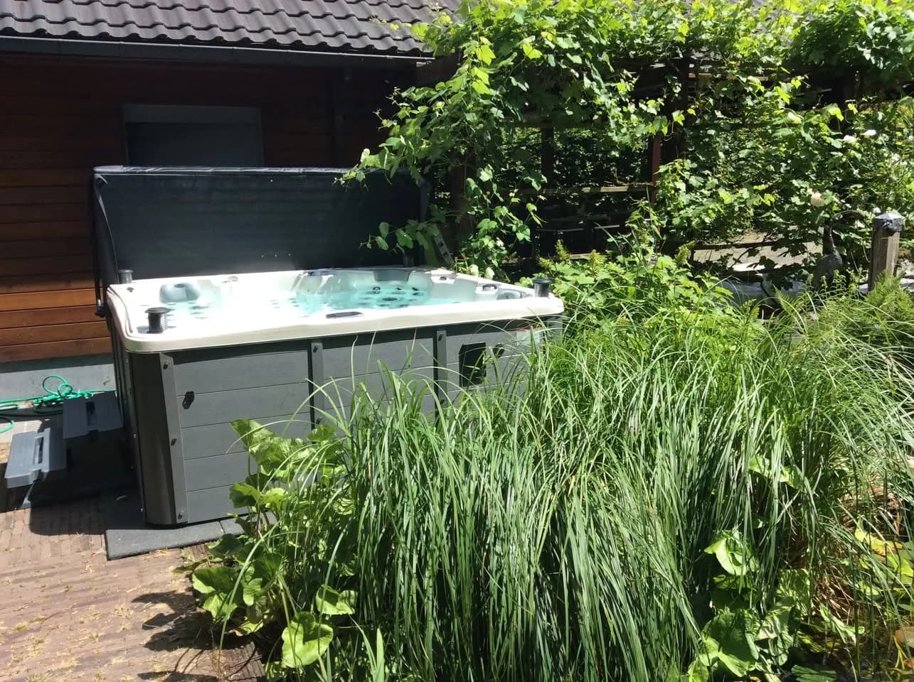 Installation d'un autre spa Sydney Full option en Belgique, dans un jardin planté, avec lève-couverture