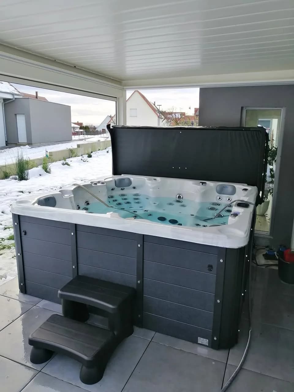 Installation d'un autre spa Vancouver dans le Doubs, sous une pergola blanche, marchepied