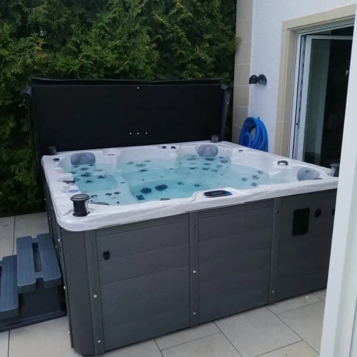 Installation d'un autre spa Vancouver Full option au Luxembourg, sur une terrasse carrelée devant une baie vitrée