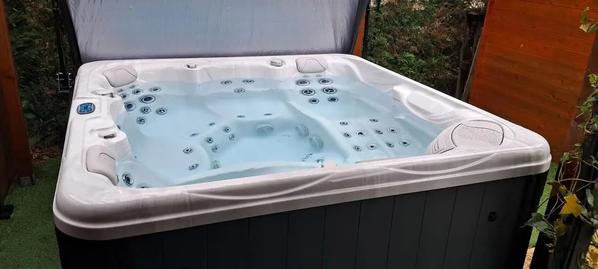 Installation d'un spa Athena à Beaune, contre un abri en bois