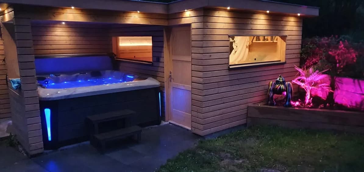 Installation d'un spa Barcelona dans le Bas-Rhin, sous un abri en bois, de nuit, éclairage LED