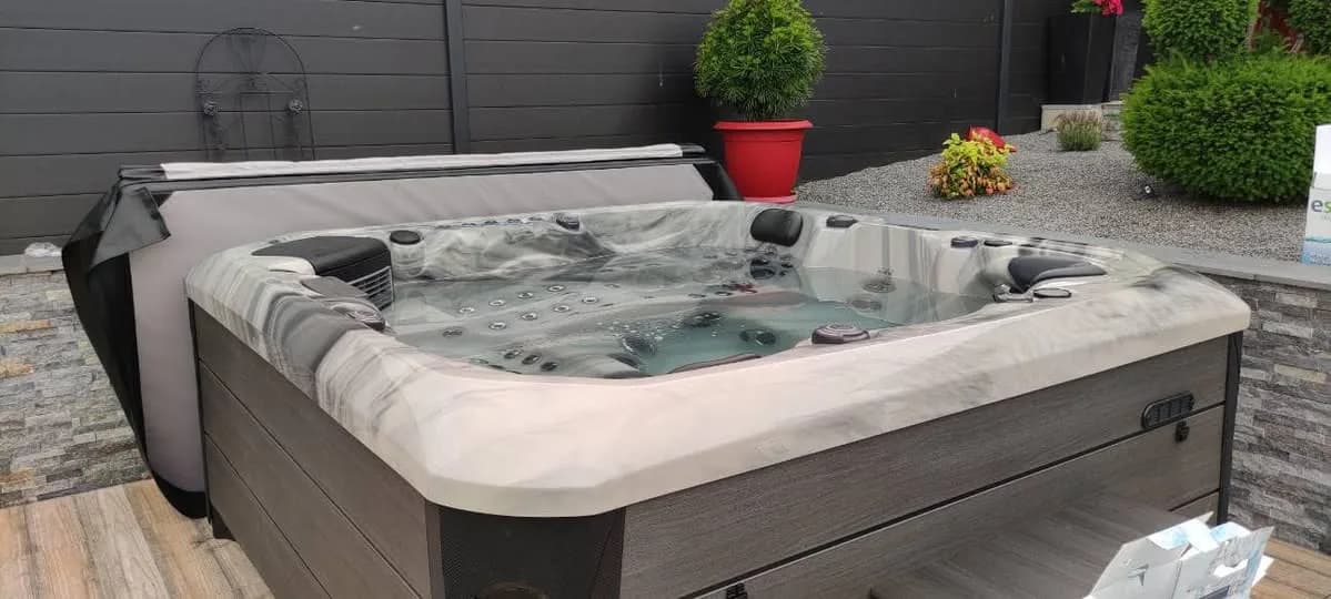 Installation d'un spa Barcelona Full option en Meurthe-et-Moselle, sur une terrasse au bord d'un jardin paysager