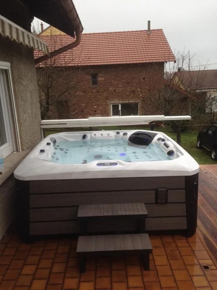 Installation d'un spa Barcelona Full option en Moselle, sur une terrasse en bois contre la maison