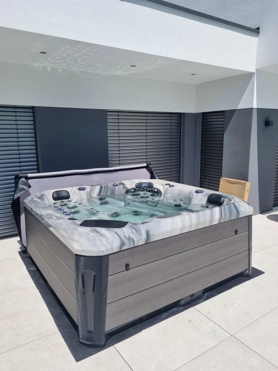 Installation d'un spa Barcelona Full option à Hundsbach, sur une terrasse carrelée sous l'avancée du toit