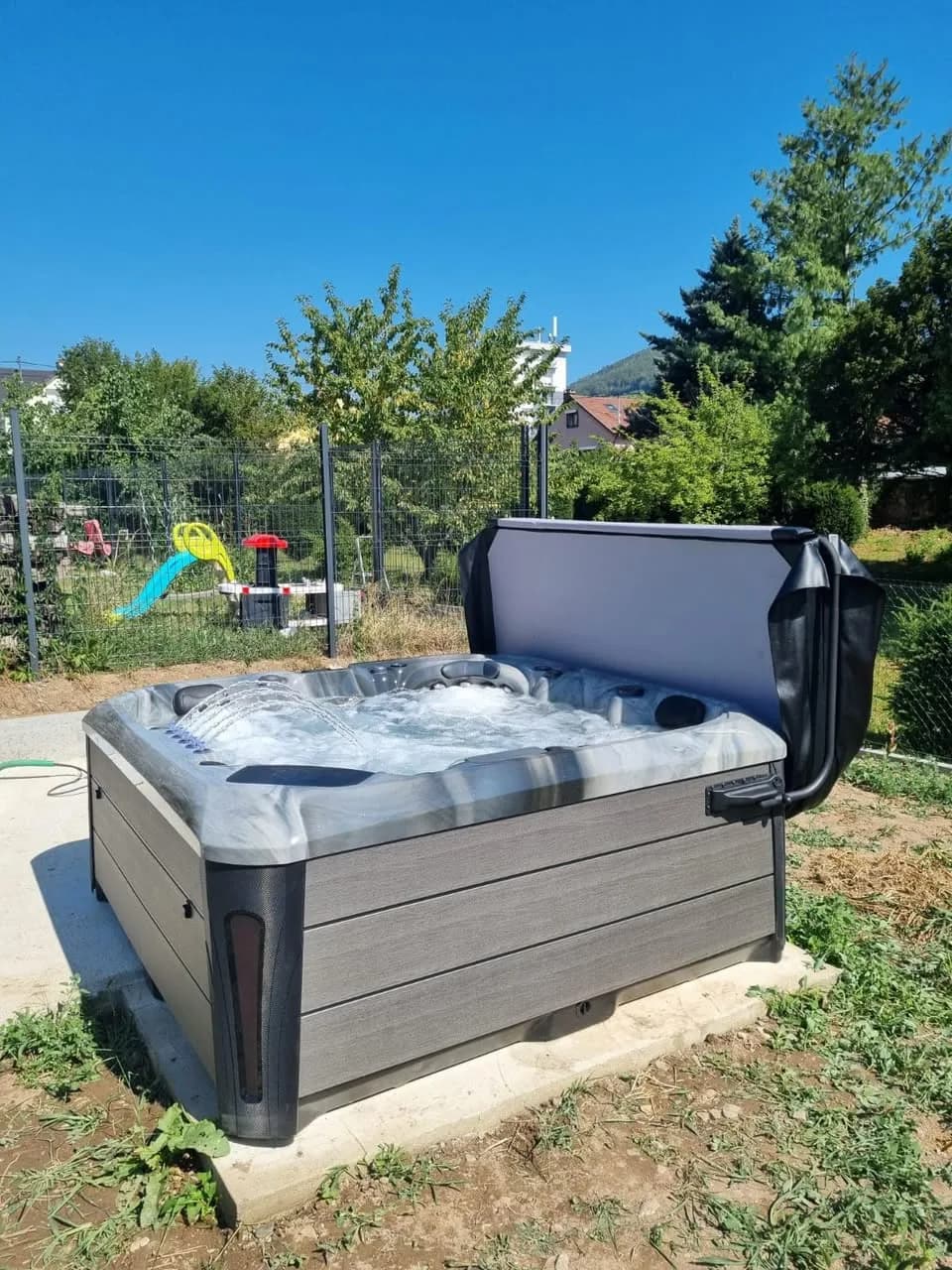 Installation d'un spa Barcelona à Soultz-Haut-Rhin, sur une dalle en bordure de pelouse