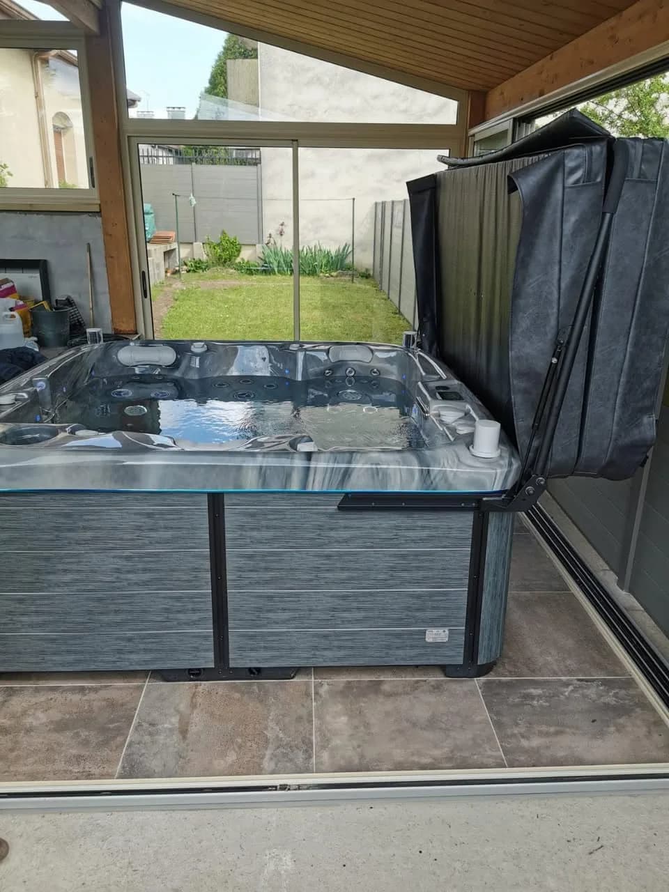 Installation d'un spa Bjørgan à Blénod-lès-Pont-à-Mousson, sous une terrasse couverte, sol carrelé