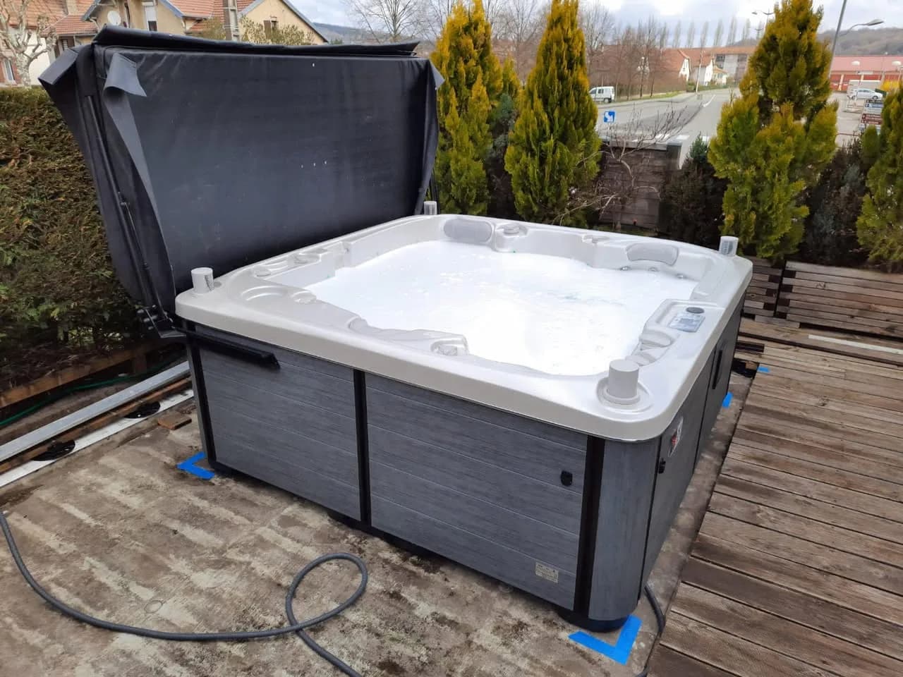 Installation d'un spa Bjørgan Full option dans le Territoire de Belfort, sur une terrasse en bois, lève-couverture