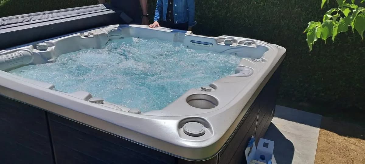 Installation d'un spa Bjørgan Full option à Fellering, dans un jardin devant une haie