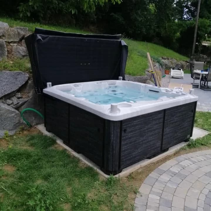 Installation d'un spa Bjørgan Full option à Sentheim, sur une dalle au pied d'un talus, avec lève-couverture