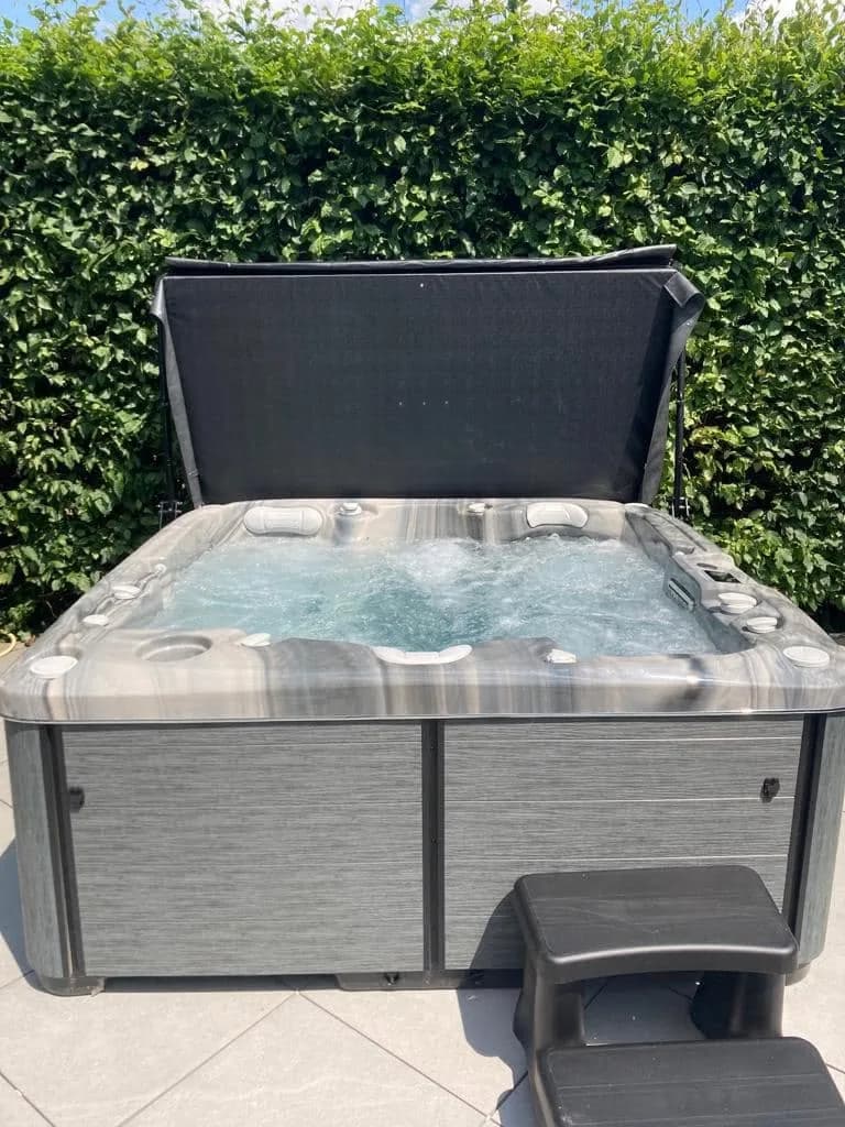 Installation d'un spa Bjørgan à Pulversheim, sur une terrasse devant une haie, cuve Odyssey