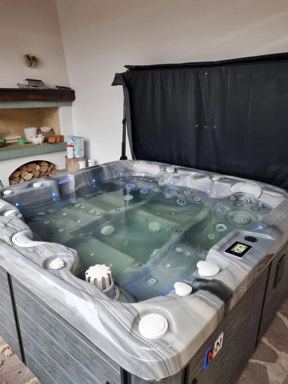 Installation d'un spa Bjørgan à Raedersheim, sous un auvent, cuve marbrée grise