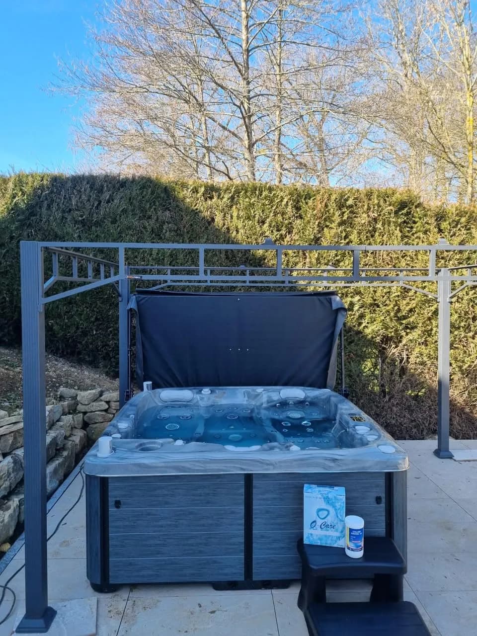 Installation d'un spa Bjørgan à Soppe-le-Bas, sur une dalle au pied d'une haie, cuve Odyssey