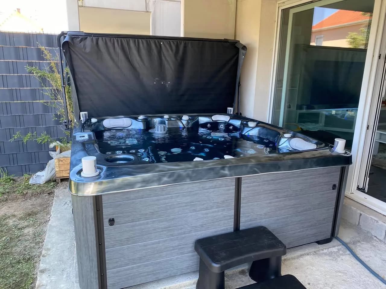 Installation d'un spa Bjørgan à Souffelweyersheim, sur une terrasse carrelée devant une baie vitrée