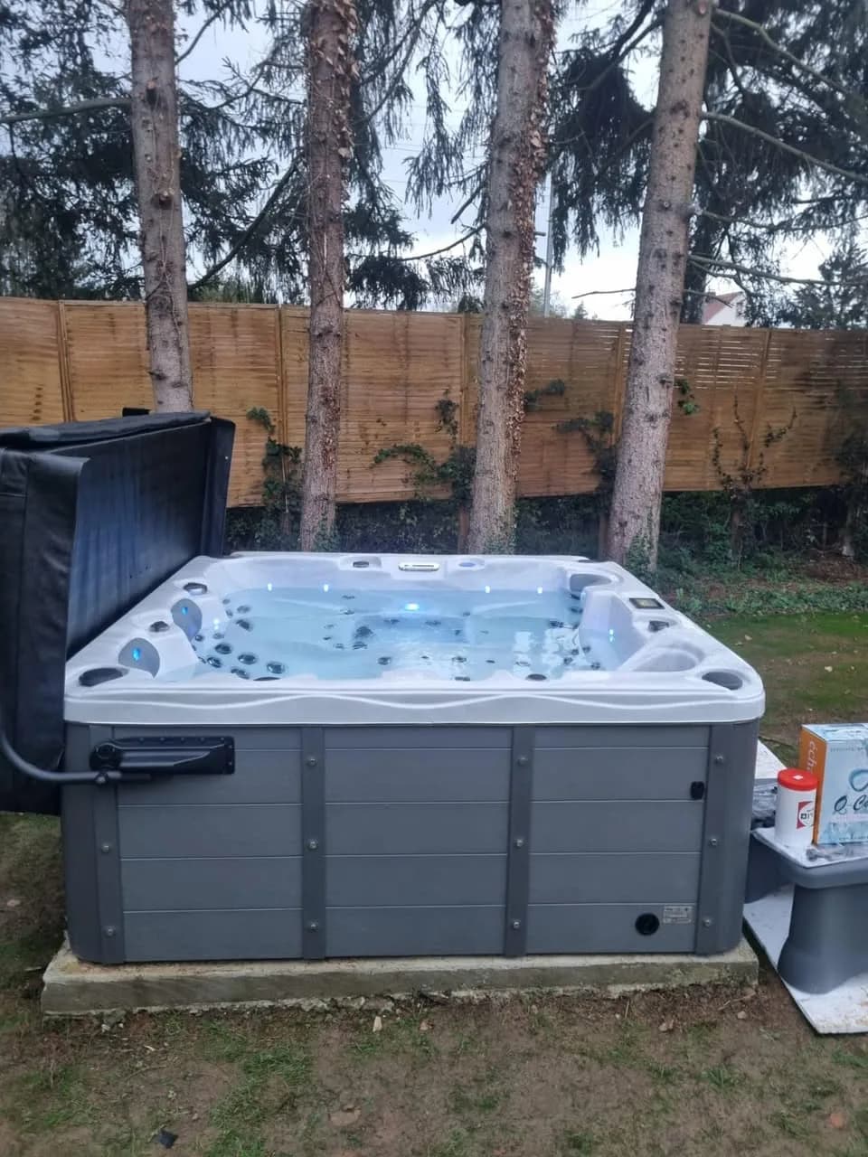 Installation d'un spa Burlington à Brunstatt, dans un jardin devant une palissade en bois