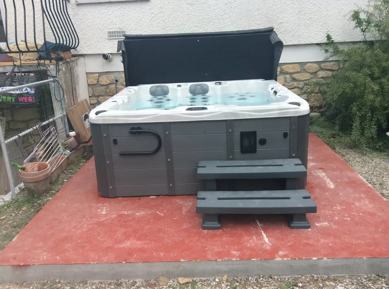 Installation d'un spa Burlington à Caen, sur une dalle rouge, lève-couverture et marchepied