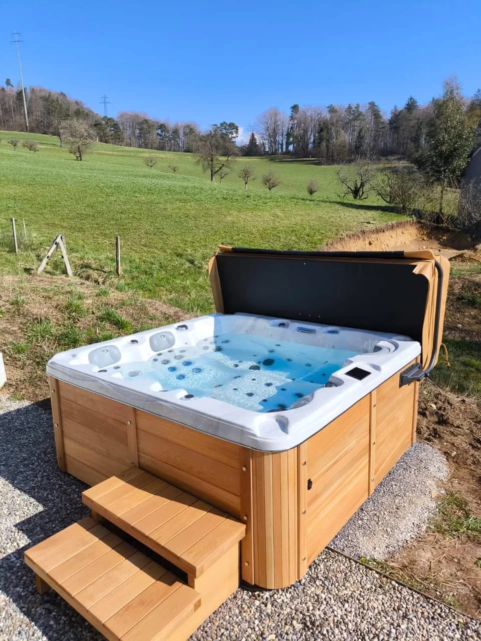 Installation d'un spa Burlington à Drinbach, en bordure d'un pré, tablier en cèdre