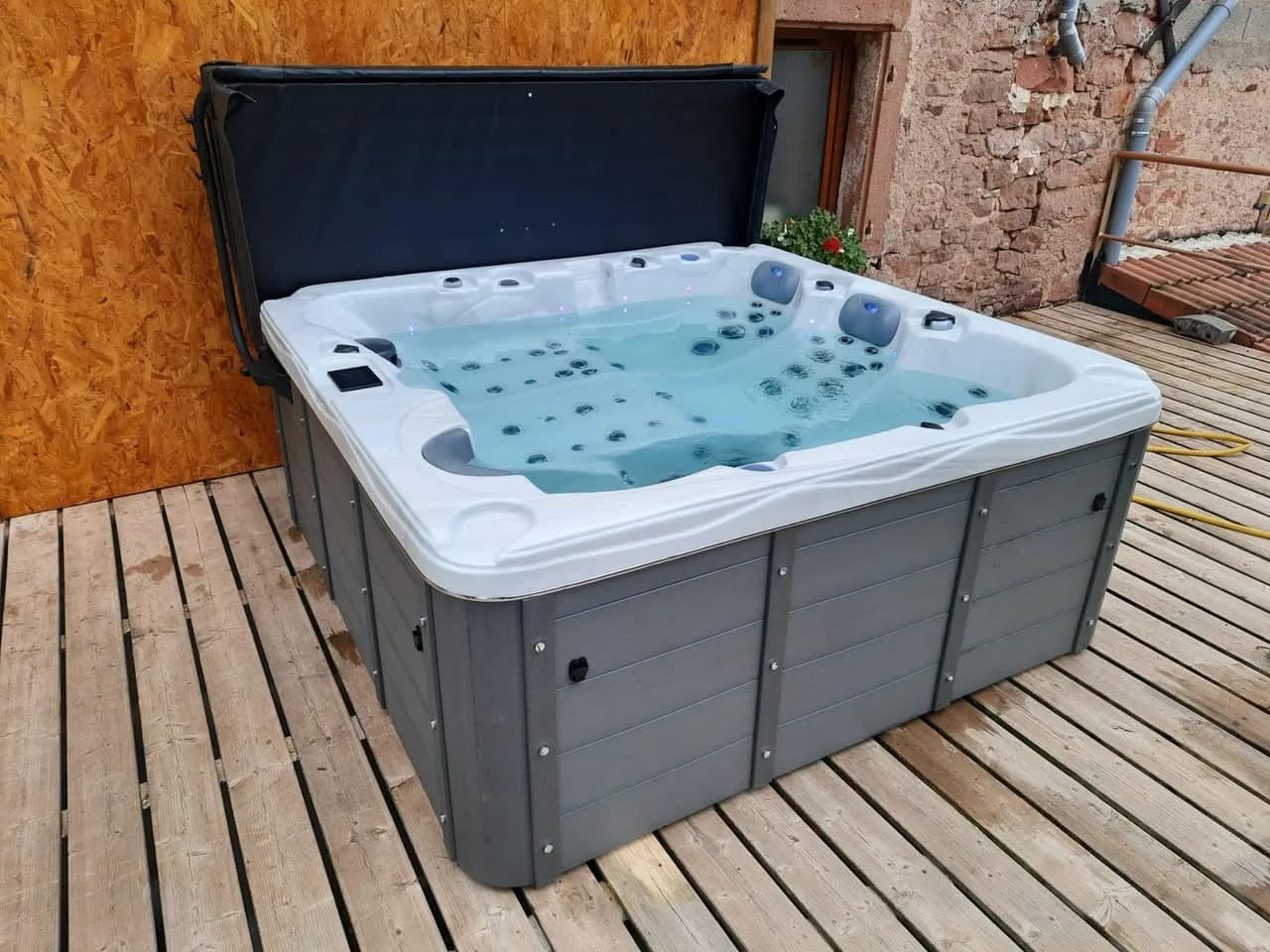 Installation d'un spa Burlington en Meurthe-et-Moselle, sur une terrasse en bois, lève-couverture