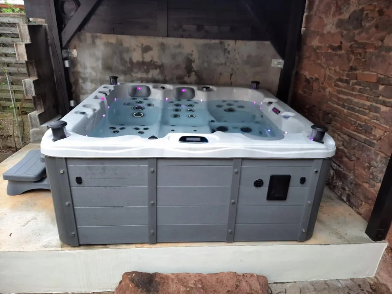 Installation d'un spa Burlington Full option à Châtenois, sous un abri, contre un mur de briques