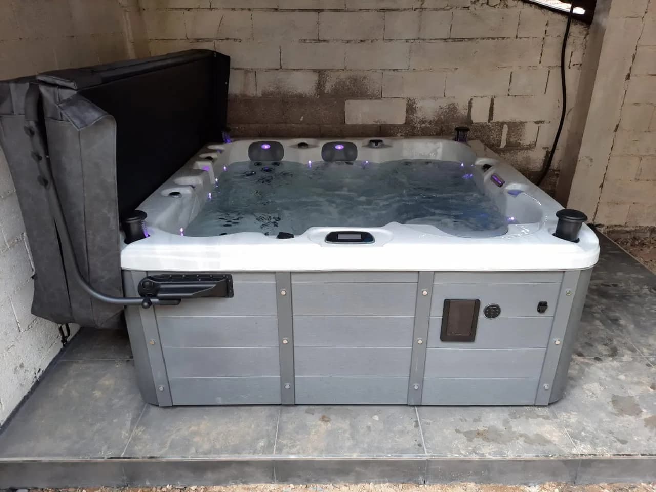 Installation d'un spa Burlington Full option à Flavigny-sur-Moselle, sur une dalle contre un mur, lève-couverture