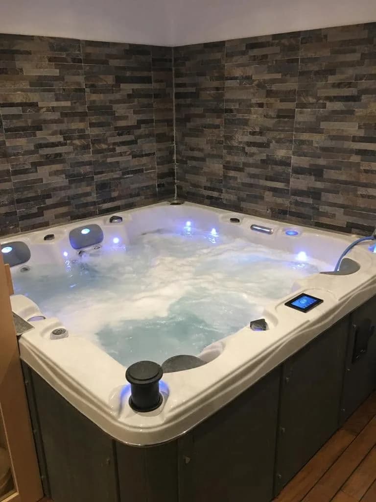 Installation d'un spa Burlington Full option à Pertuis, contre un mur en parement de pierre