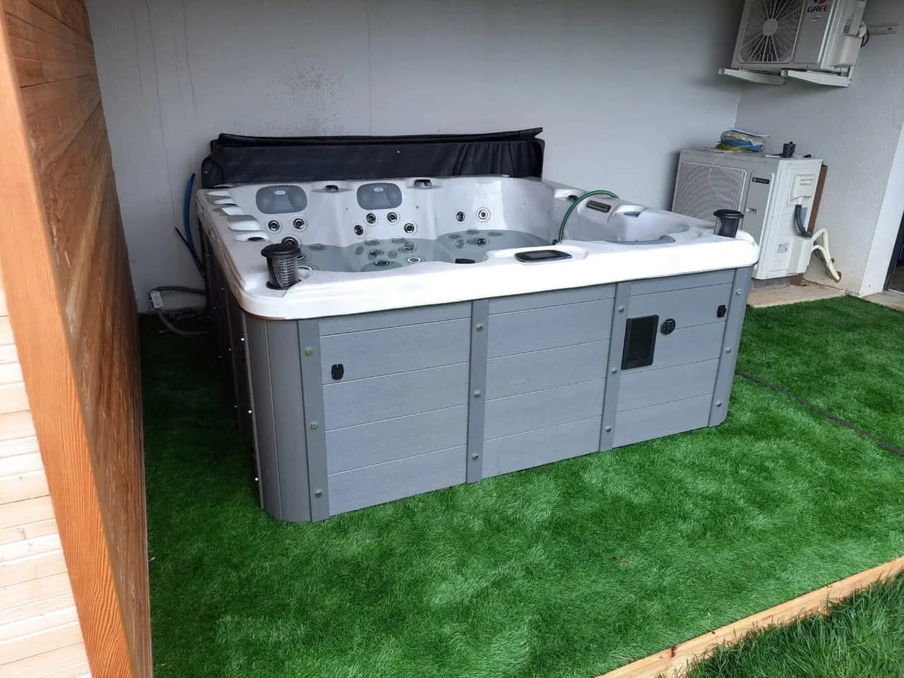 Installation d'un spa Burlington à Messein, sur un gazon synthétique sous un abri ouvert