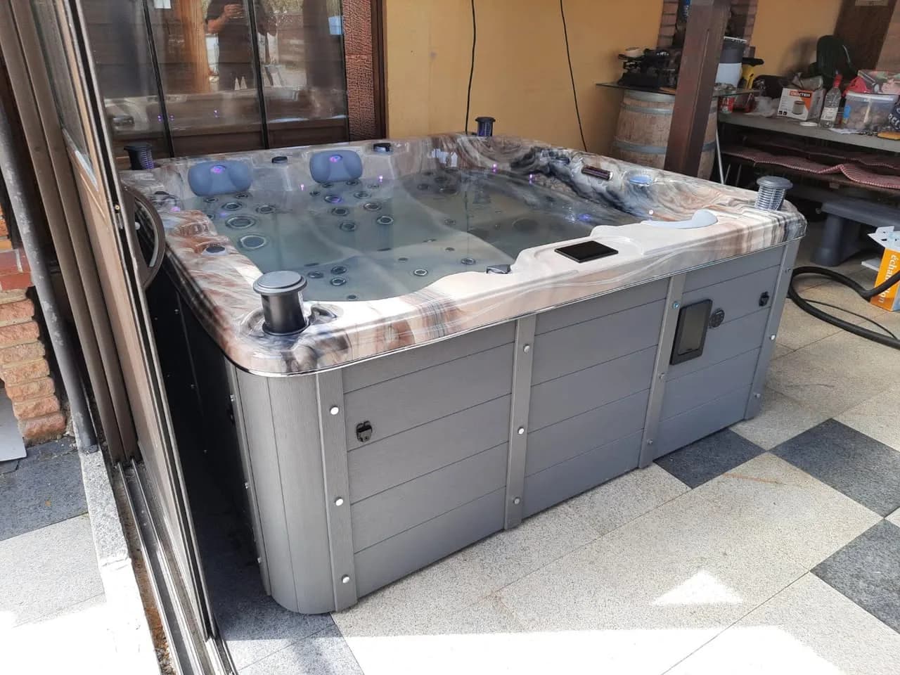 Installation d'un spa Burlington à Muespach, sous un abri vitré, sol carrelé
