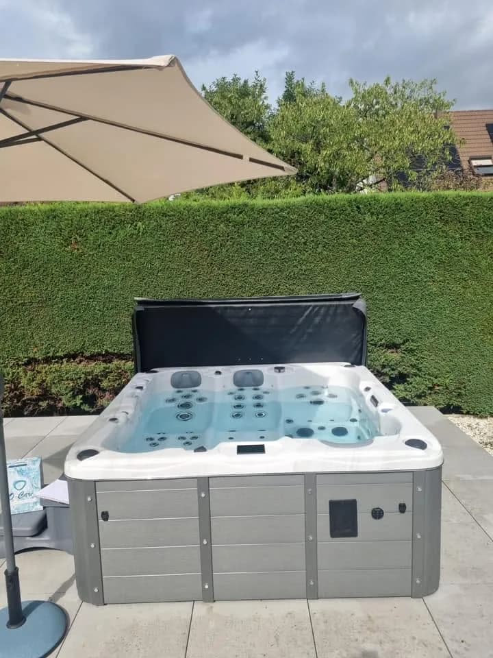 Installation d'un spa Burlington à Ruelisheim, sur un dallage au pied d'une haie