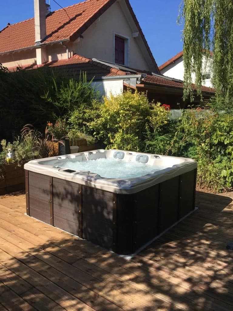 Installation d'un spa Burlington à Yerres, sur une terrasse en bois dans un jardin arboré