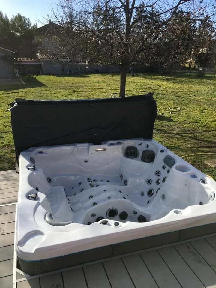 Installation d'un spa Cambridge à Cezieux, sur une terrasse en lames dans un grand jardin