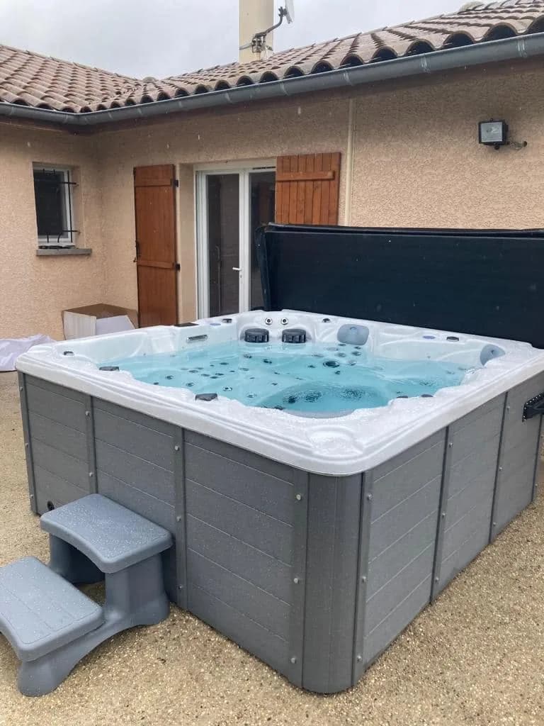 Installation d'un spa Cambridge à Chaveyriat, sur du gravier près de la maison, marchepied
