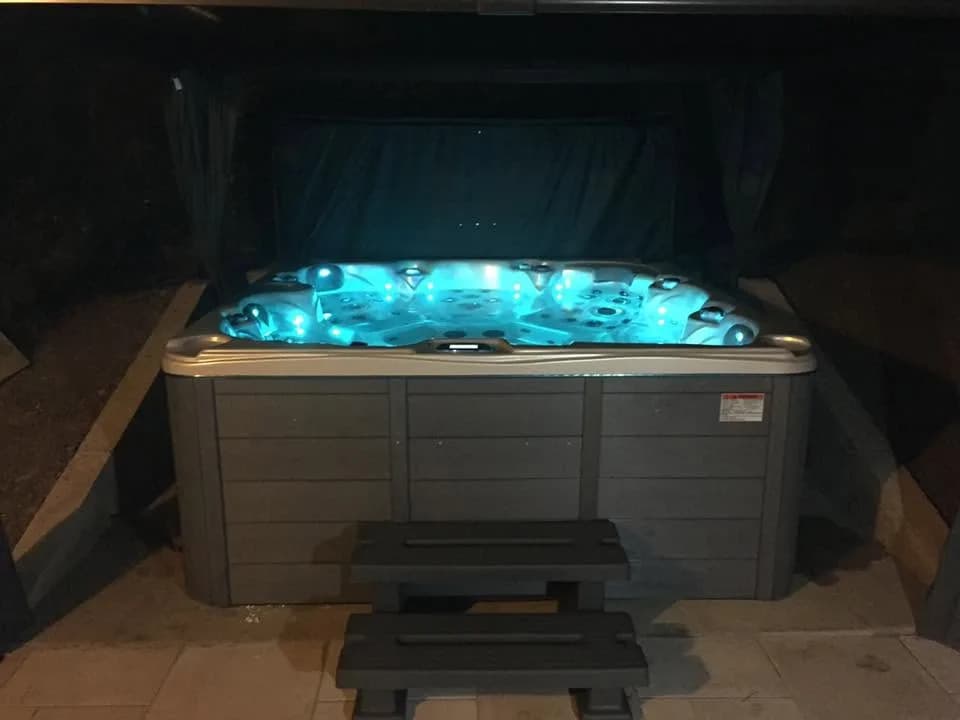 Installation d'un spa Cambridge Duel en Seine-et-Marne, sous un abri à rideaux, de nuit