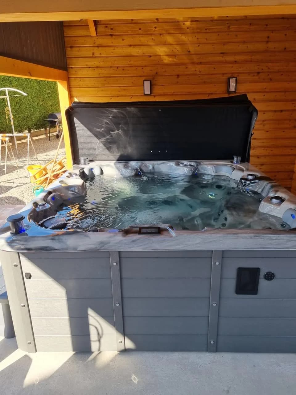Installation d'un spa Cambridge Duel à Ensisheim, sous un abri en bois, cuve marbrée grise