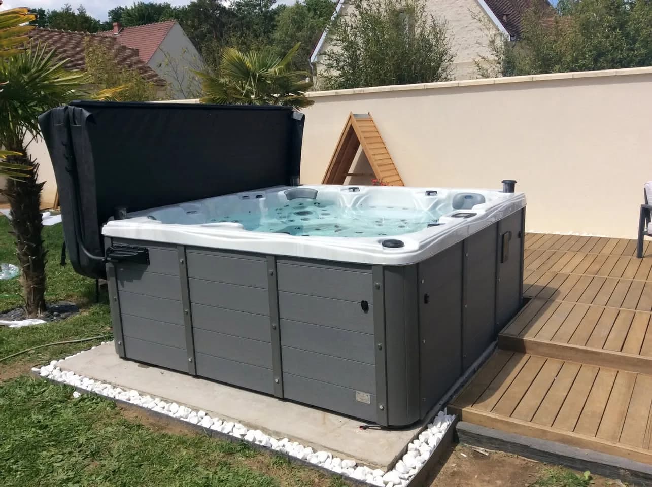 Installation d'un spa Cambridge Duel Full option à Agnetz, sur une dalle bordée de galets blancs