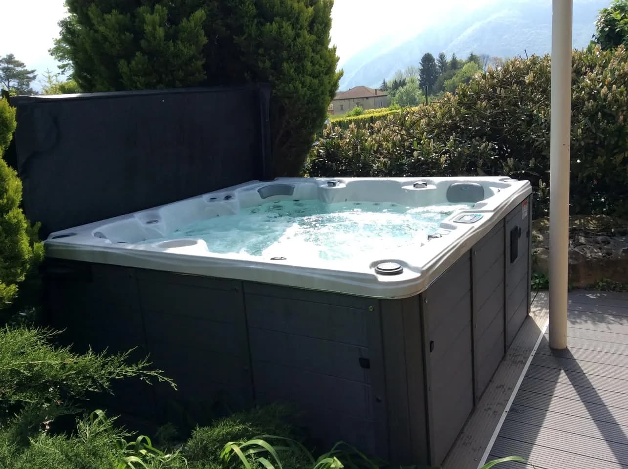 Installation d'un spa Cambridge Duel Full option en Isère, sur une terrasse carrelée en bordure de jardin