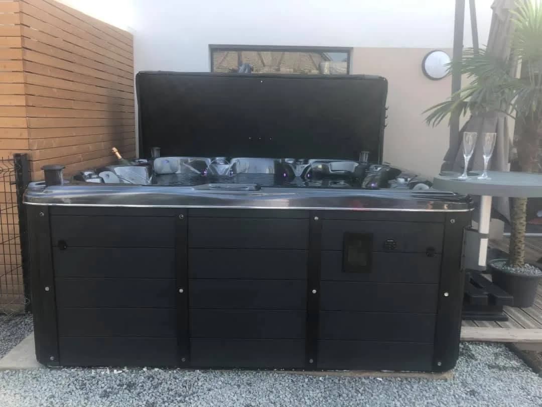 Installation d'un spa Cambridge Duel Full option à Froeningen, sur une terrasse contre un bardage en bois