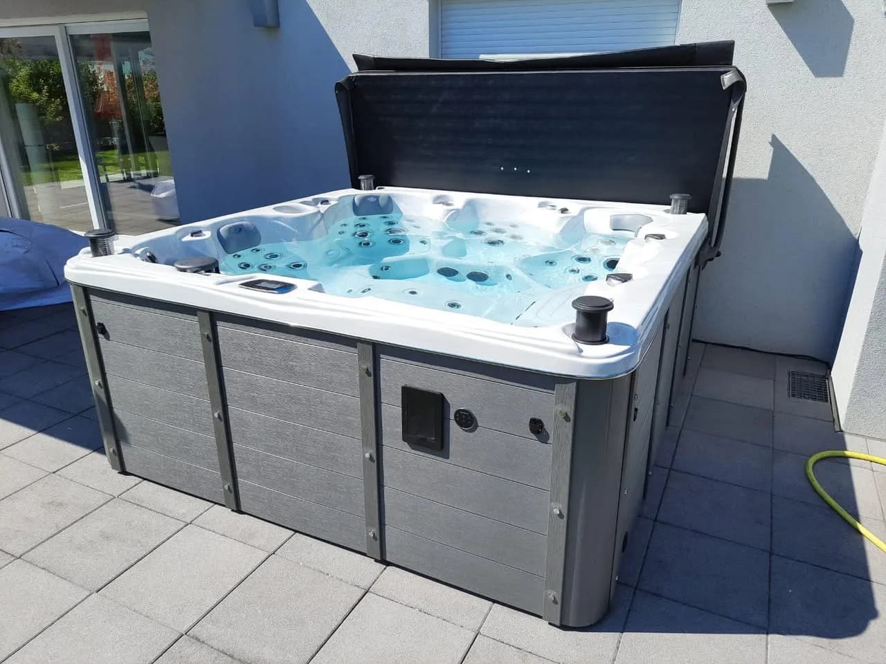 Installation d'un spa Cambridge Duel Full option à Houssen, sur une terrasse carrelée, lève-couverture