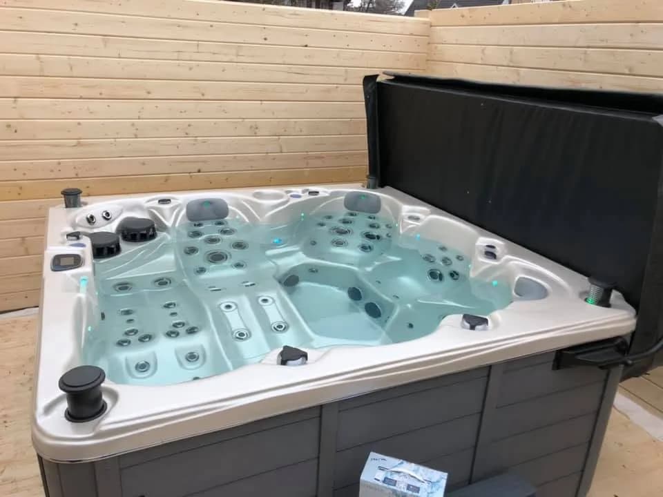 Installation d'un spa Cambridge Duel Full option à Ohlungen, contre un bardage en bois clair