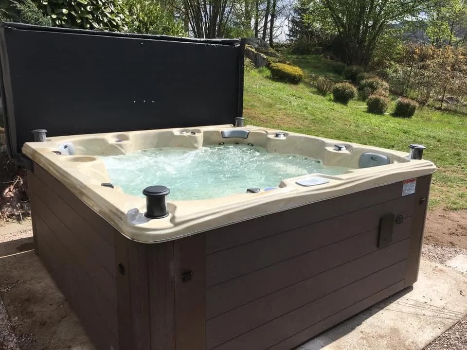 Installation d'un spa Cambridge Duel Full option à Saint-Amé, dans un jardin, lève-couverture