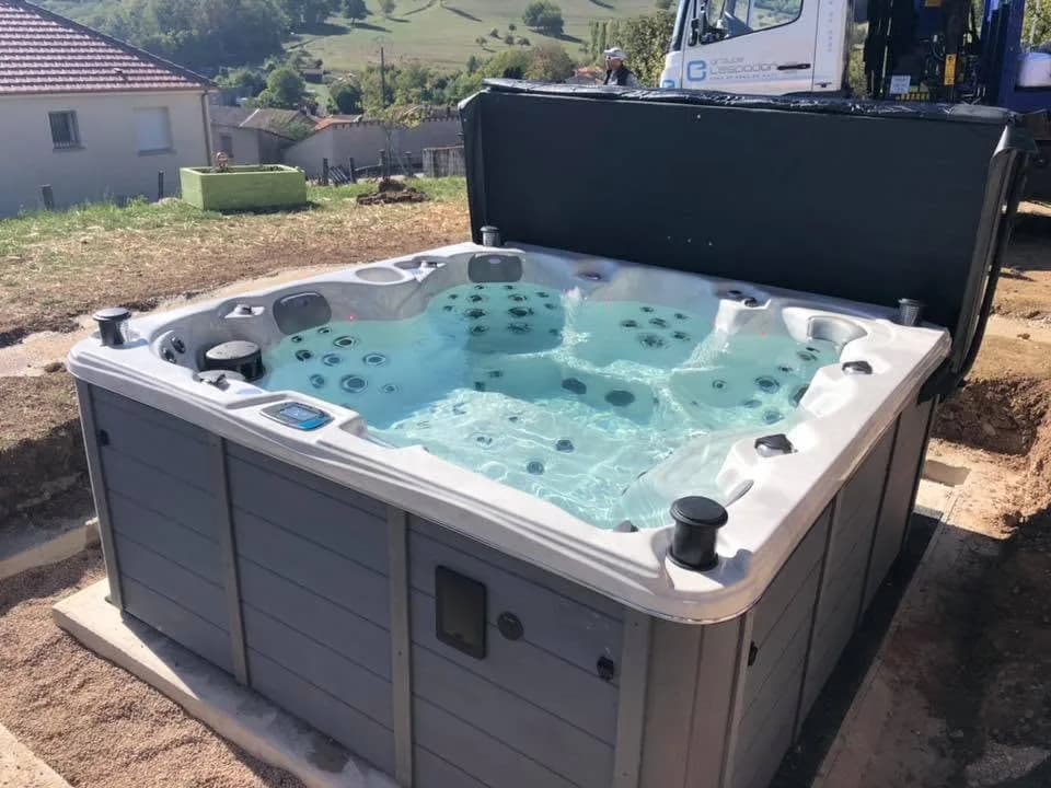 Installation d'un spa Cambridge Duel Full option à Socourt, dans un jardin en cours d'aménagement, vue sur la vallée