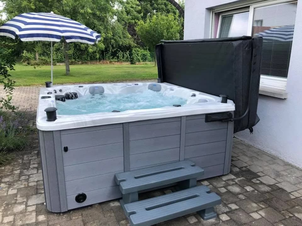 Installation d'un spa Cambridge Duel Full option à Soultz-Haut-Rhin, sur un sol pavé, marchepied