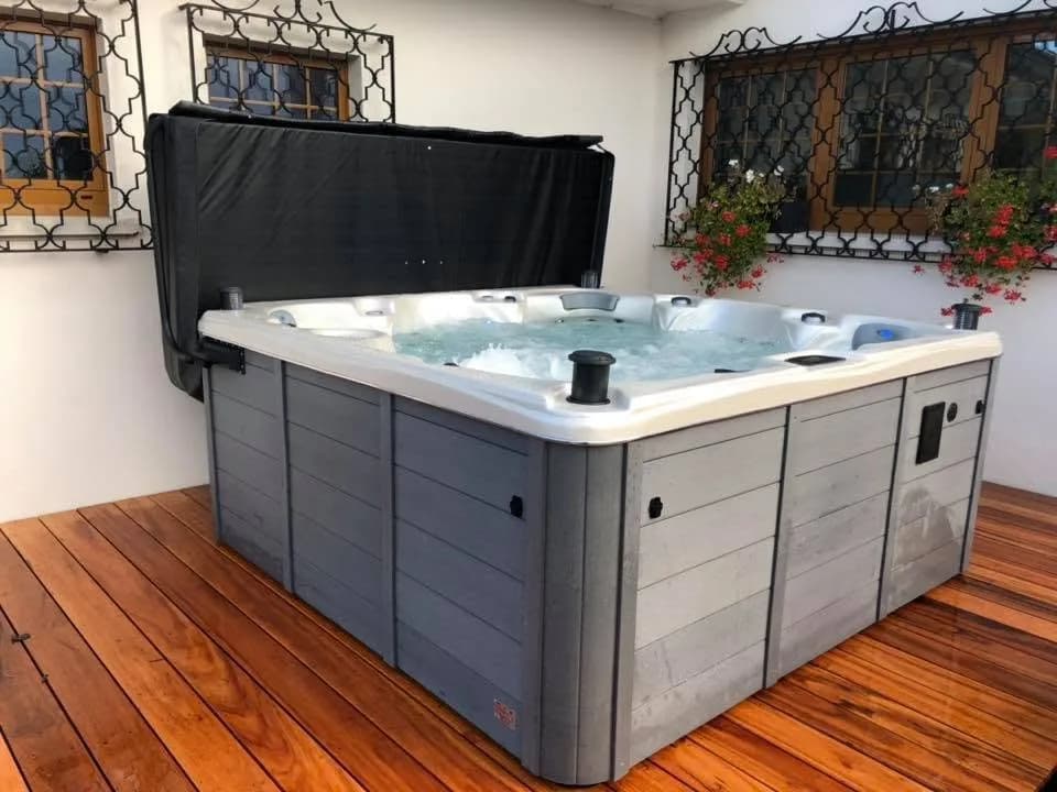 Installation d'un spa Cambridge Duel Full option à Zimmersheim, sur une terrasse en bois contre la maison