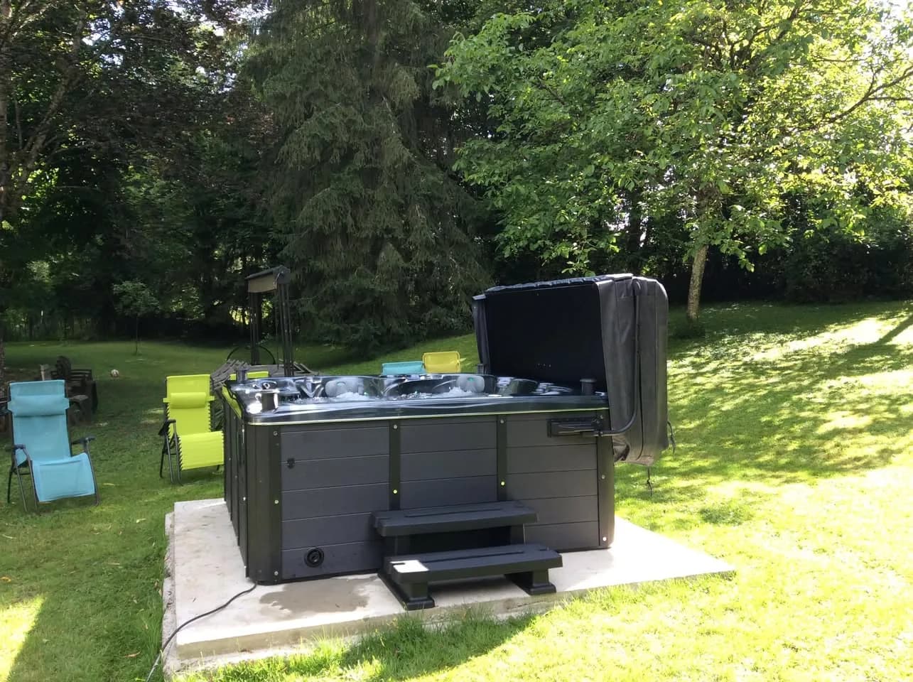 Installation d'un spa Cambridge Duel à Gray, sur une dalle dans un jardin arboré