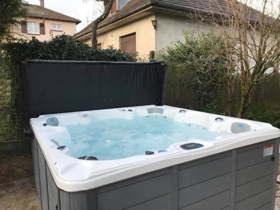 Installation d'un spa Cambridge Duel à Mulhouse, dans le jardin devant une haie