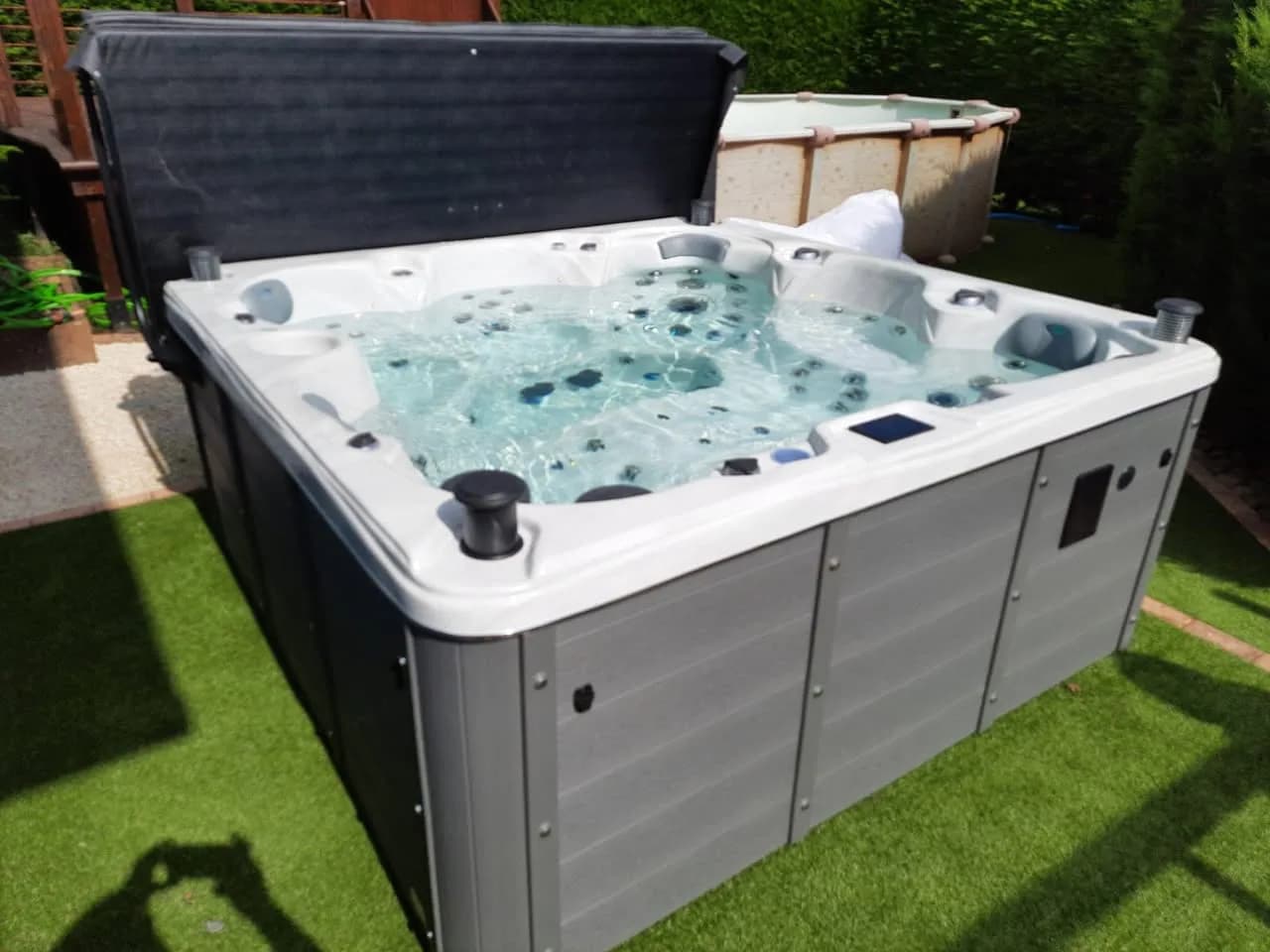 Installation d'un spa Cambridge Duel à Oberbruck, sur un gazon synthétique, lève-couverture