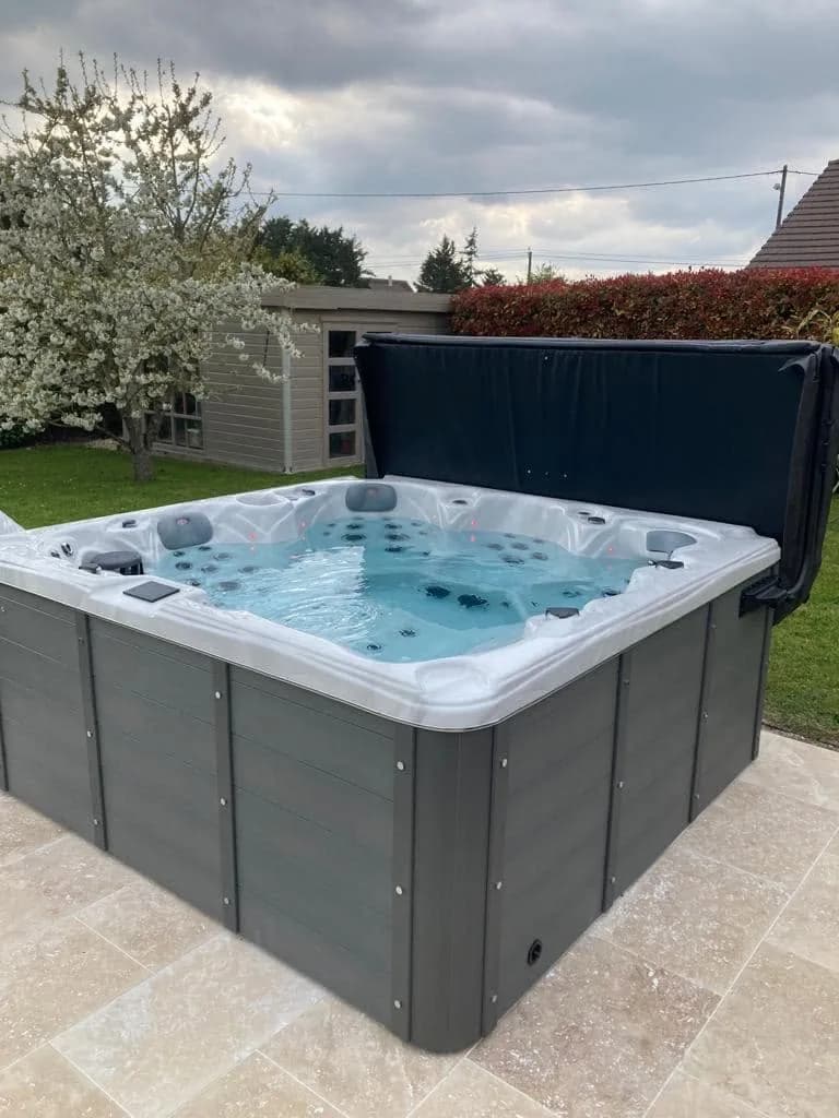 Installation d'un spa Cambridge à Saint-Lubin-de-la-Haye, sur une dalle claire en bordure de pelouse