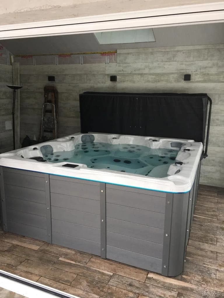 Installation d'un spa Cambridge à Segny, dans une pièce ouverte sur le jardin