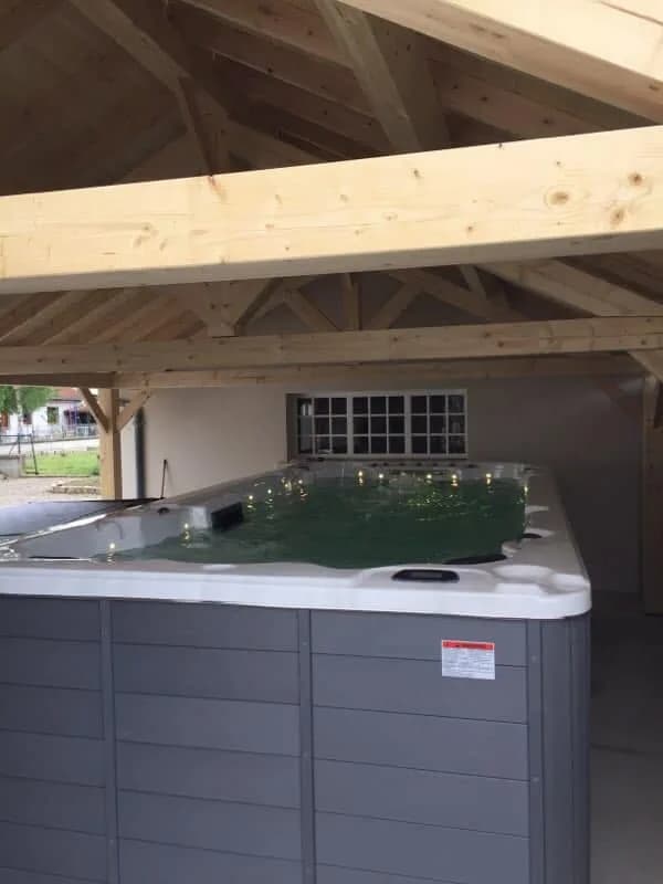 Installation d'un spa de nage Full option dans le Territoire de Belfort, sous un abri à charpente en bois